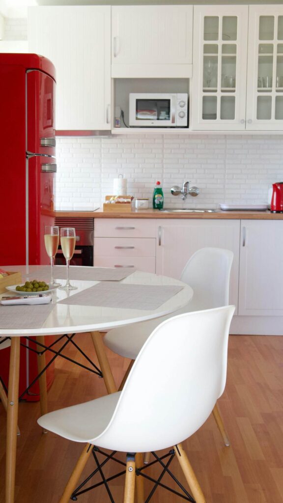 Small-kitchen-makeover-idea-with-a-red-fridge-white-walls-and-a-little-dining-corner-that-brings-modern-and-charm-to-the-space