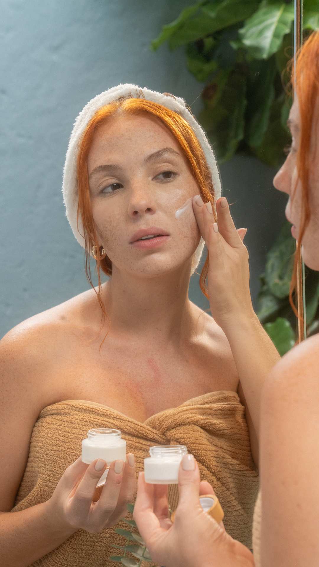 Simple-morning-skincare-routine-for-women-a-woman-in-towel-applies-face-moisturizer-for-healthy-glowing-skin