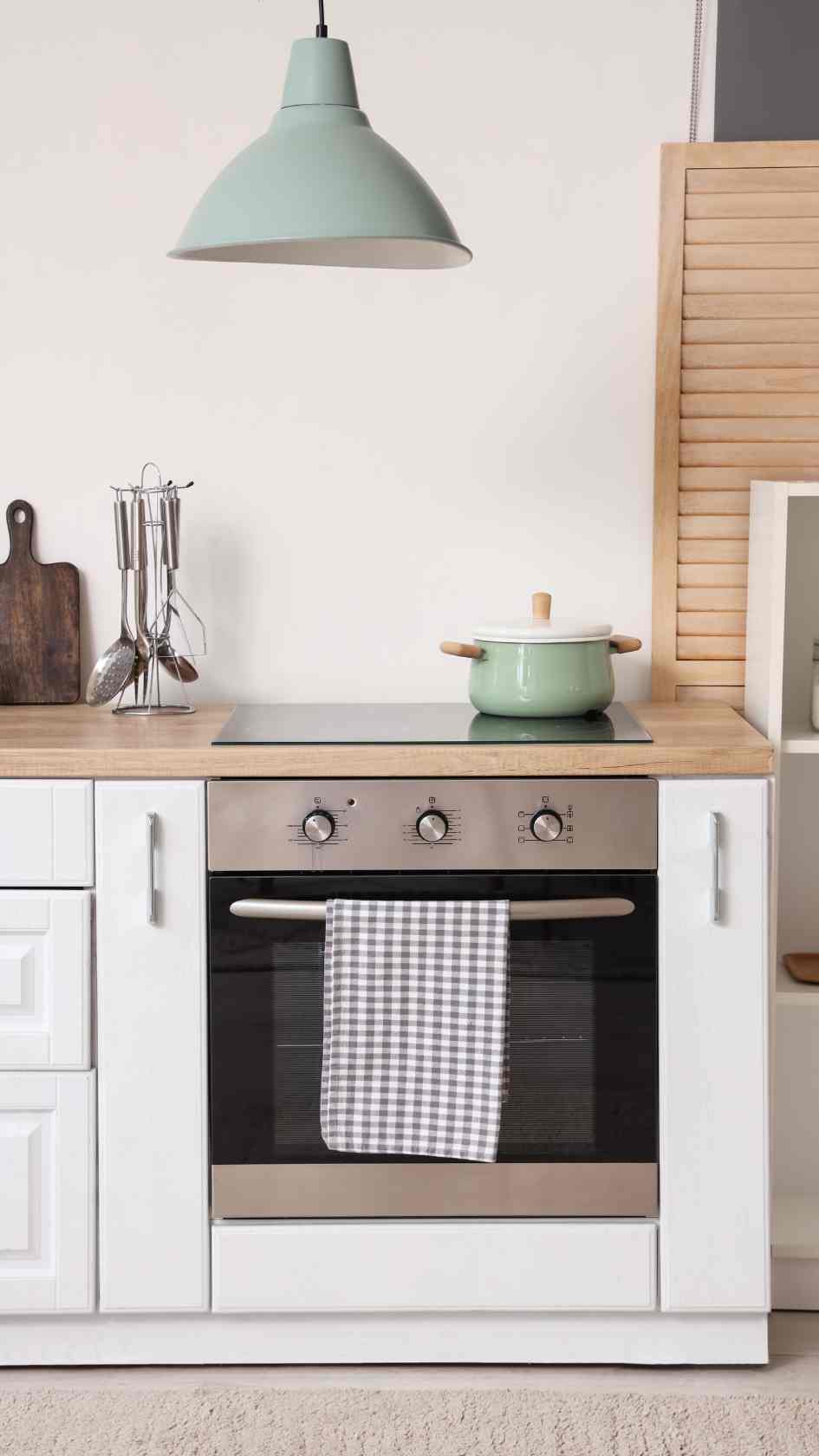 Bright-kitchen-with-black-and-silver-countertop-white-cabinets-glass-jars-and-a-pegboard-with-cutting-board