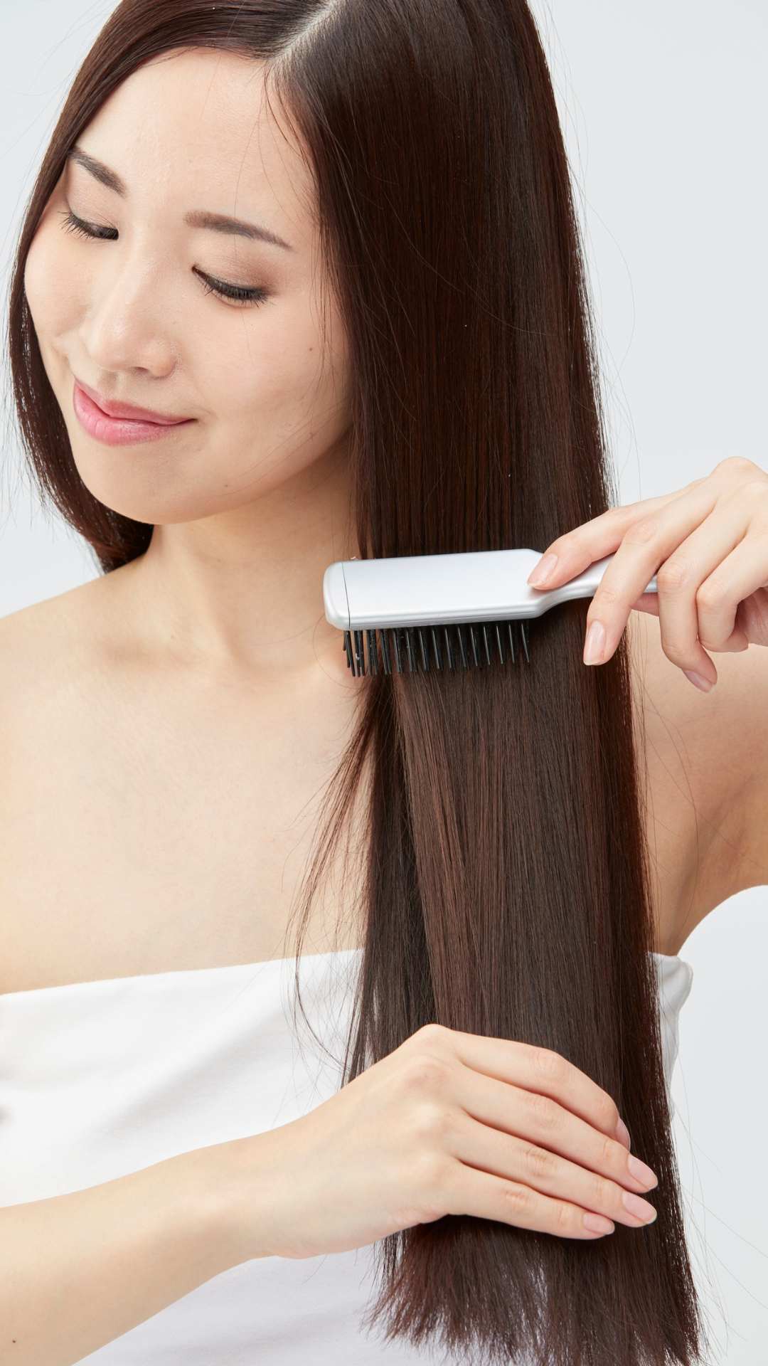 A-woman-in-a-white-towel-combining-her-hair-gently