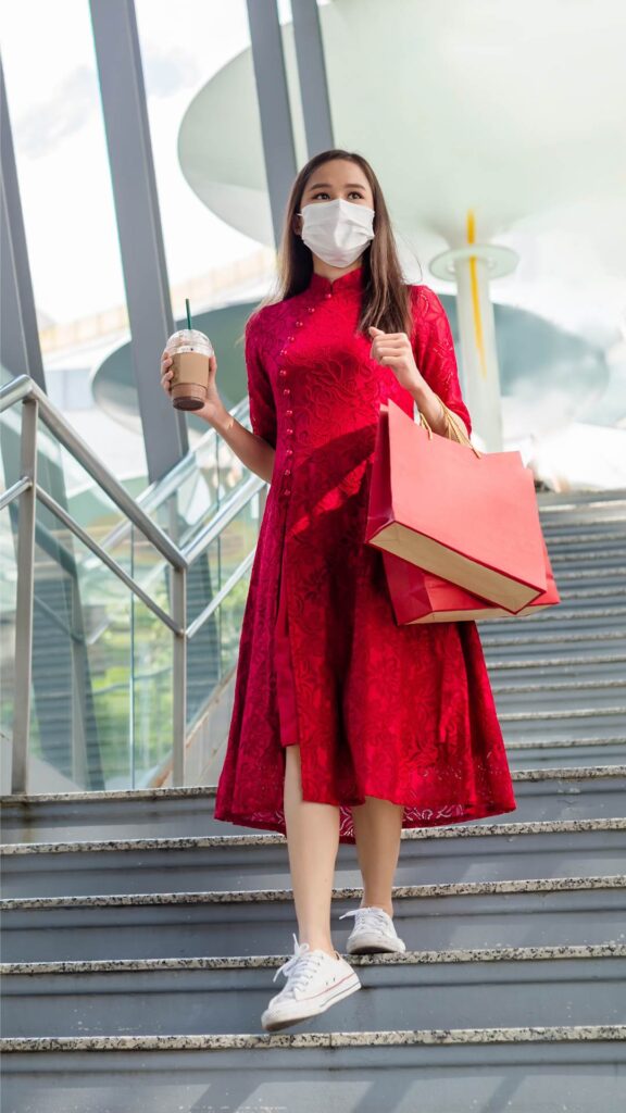 A-woman-wearing-a-casual-red-flowy-gown-and-walking-down-the-stair-case-after-shopping-for-her-valentine-gifts