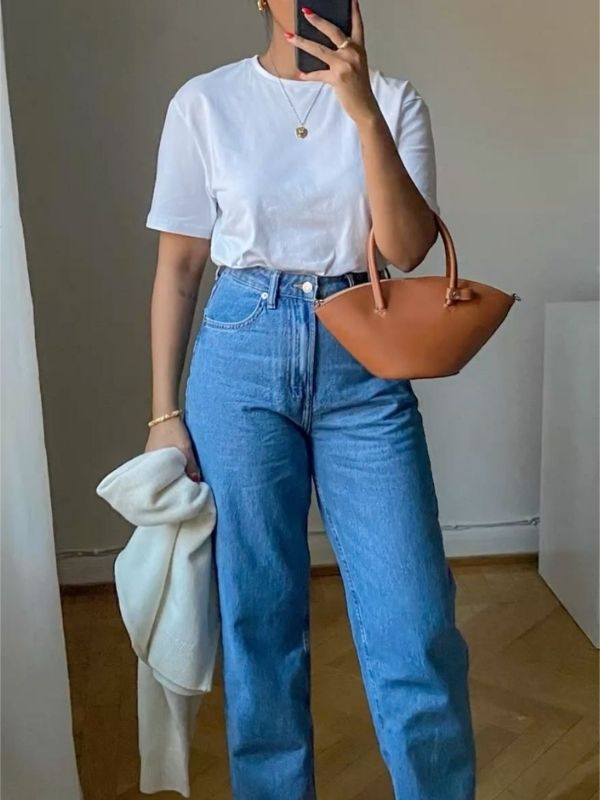 A-woman-wearing-Classic-wears-denim-jeans-white-Tee-while-carrying-her-brown-handbag