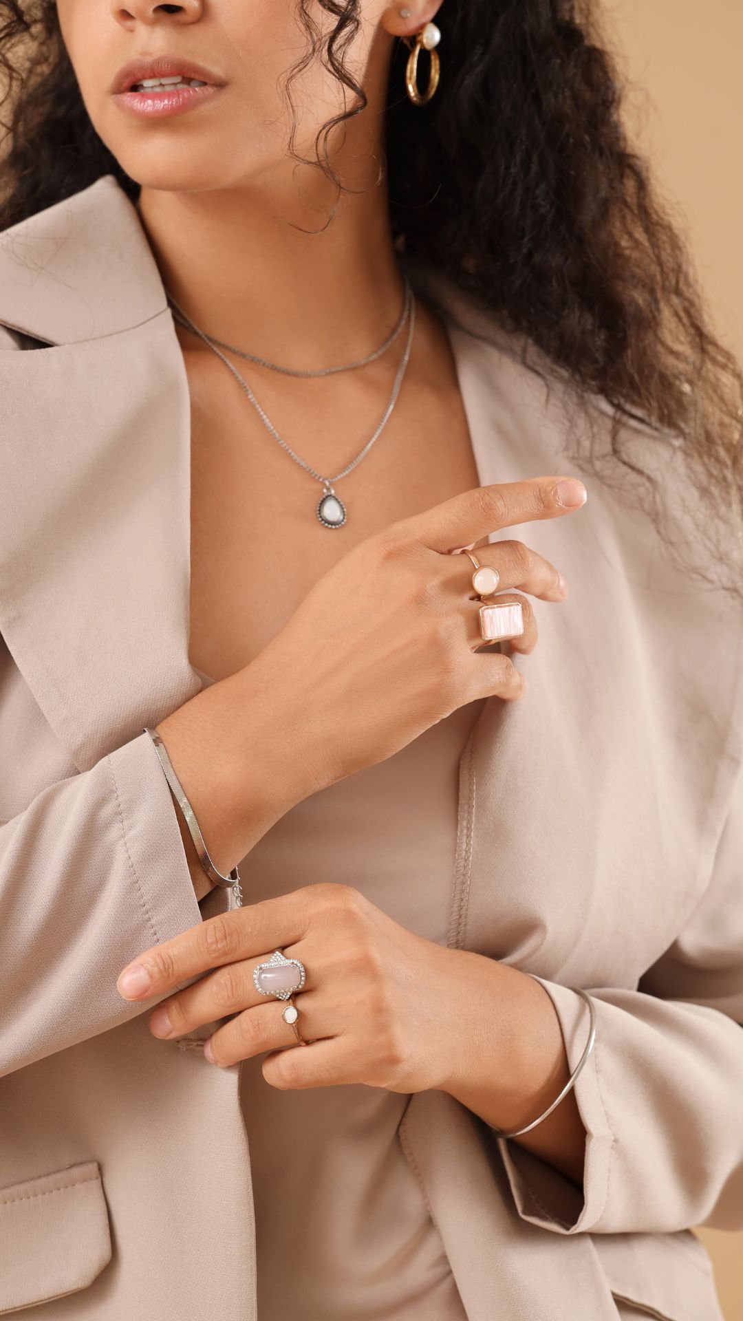 A-woman-wearing-minimalist-jewelries-for-simple-and-everyday-pieces-comprising-of-silver-rings-necklace-bracelet-and-gold-earring