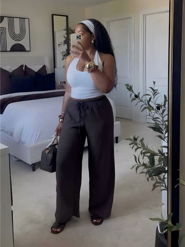A-woman-standing-infront-of-the-mirror-while-wearing-a-black-linen-pant-and-a-tank-top-as-her-casual-outfit-for-women