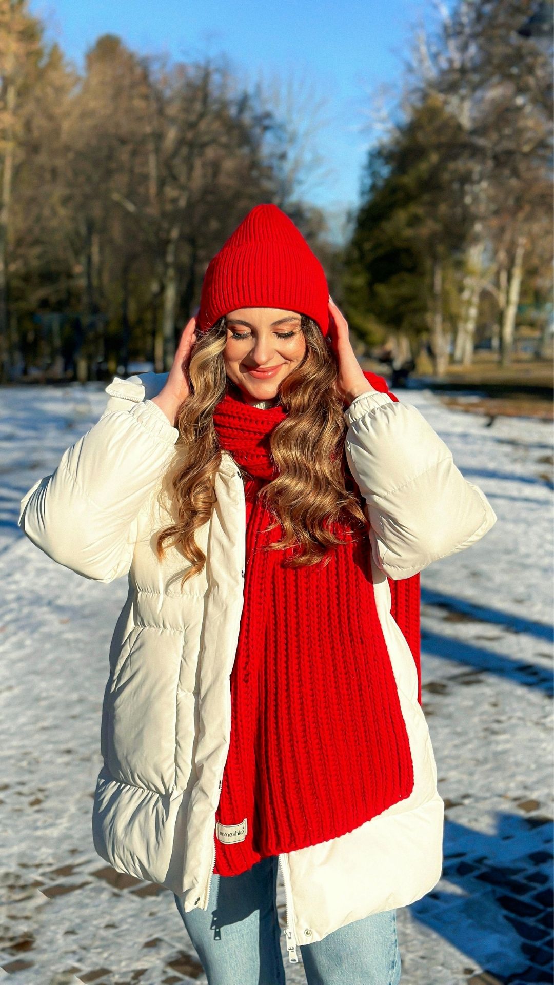 Featured-image-of-15-winter-fashion-inspo-showing-a-woman-wearing-a-red-top-red-beanie-and-white-puffer-jacket-standing-in-the-road