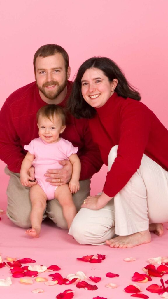 Father-mother-and-child-smiling-together-surrounded-by-hearts-and-cheerful-decorations-in-a-cozy-love-themed-illustration.