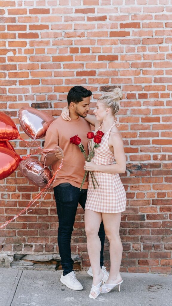Outdoor-romance-with-lovers-holding-a-balloon-and-a-rose-flower