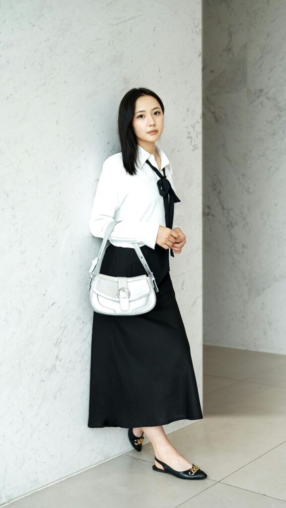 A-woman-wearing-black-skirt-and-white-shirt-as-her-easter-outfits-ideas-while-standing