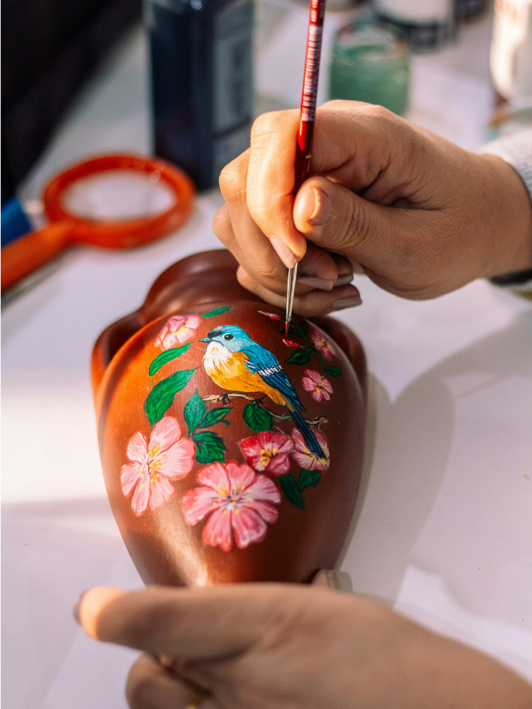 A-man-painting-a-terracotta-pot