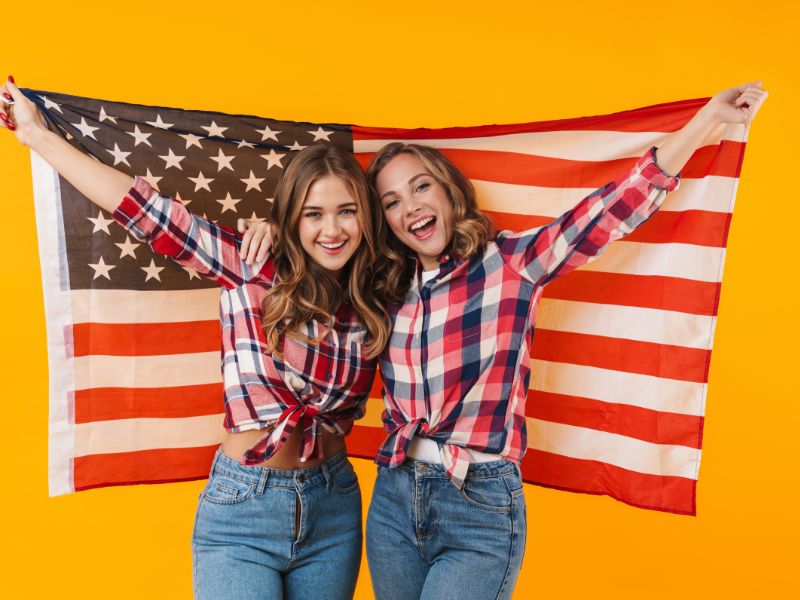 featured-image-ofbudget-friendly-diy-for-4th-of-july-shirt-ideas-showing-2-women-wearing-american-deesign-type-of-shirt-and-holding-a-flag