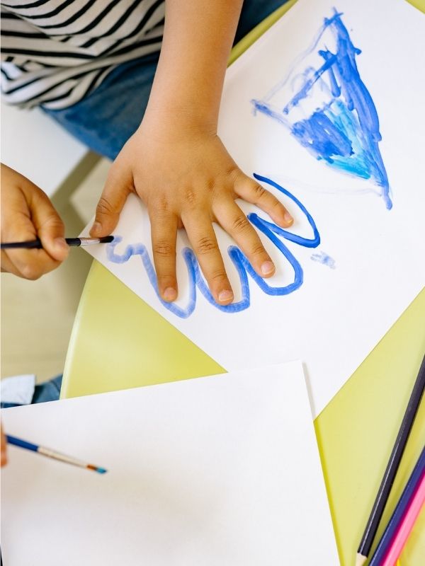 Summer-crafts-for-preschoolers-showing-a-boy-drawing-he's-hand