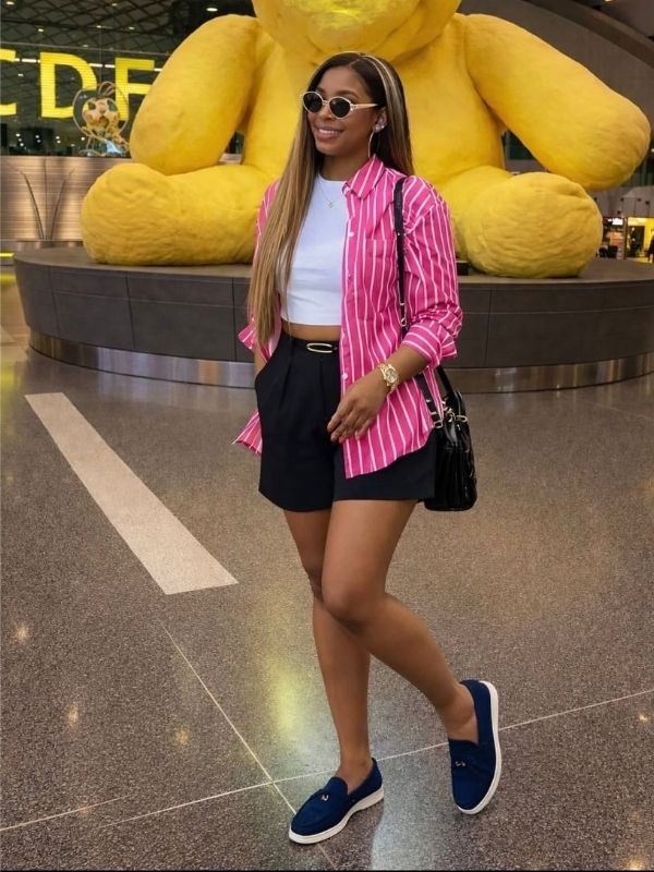 A-lady-wearing-a-white-tank-top-and-pink-oversized-shirt-with-black-shorts
