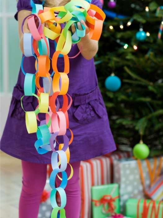 A-child-holding-Rainbow-Paper-Chain-as--7-easy-arts-and-crafts-for-kids-to-do-at-home-when-theyre-bored