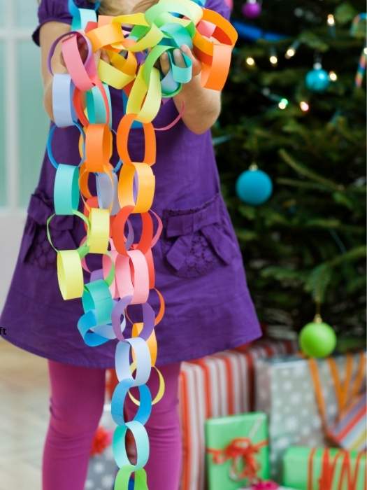 A-girl-holding-Christmas-Paper-Chain-craft-as-part-of-the-10-simple-christmas-crafts-for-kids-that-are-fun-and-simple-to-make