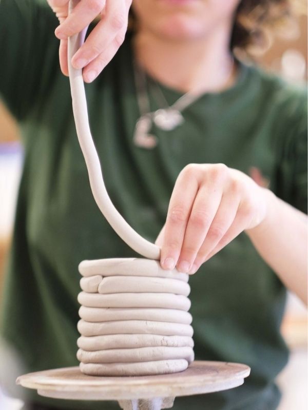 An-image-of-a-woman-coiling-a-clay-pot