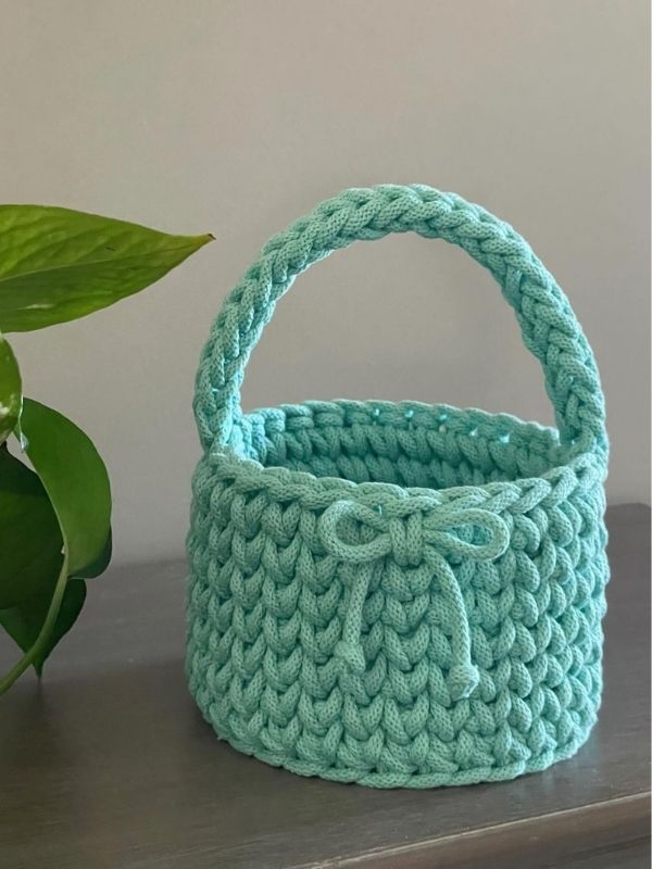 Handmade-rope-basket-with-sturdy-braided-handles-sitting-on-a-wooden-surface